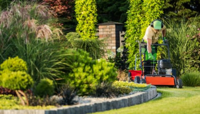 man performing spring core lawn aeration
